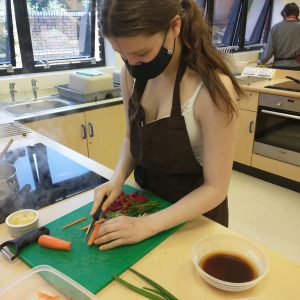 teenage girl chopping vegetables